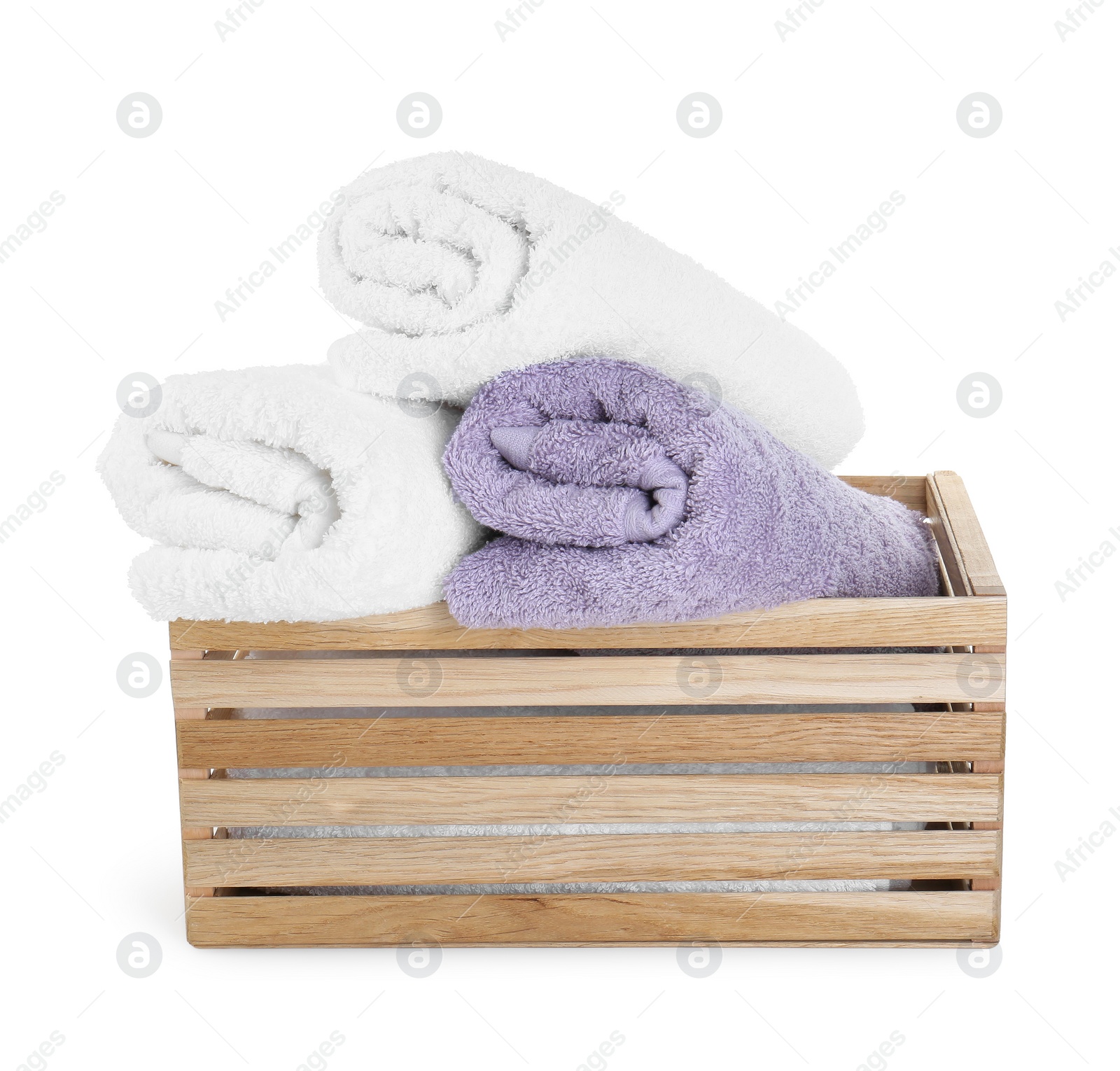 Photo of Rolled terry towels in wooden crate isolated on white