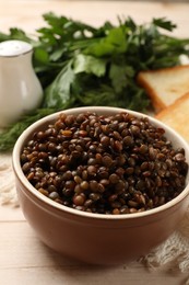 Photo of Delicious lentils in bowl served on table, closeup