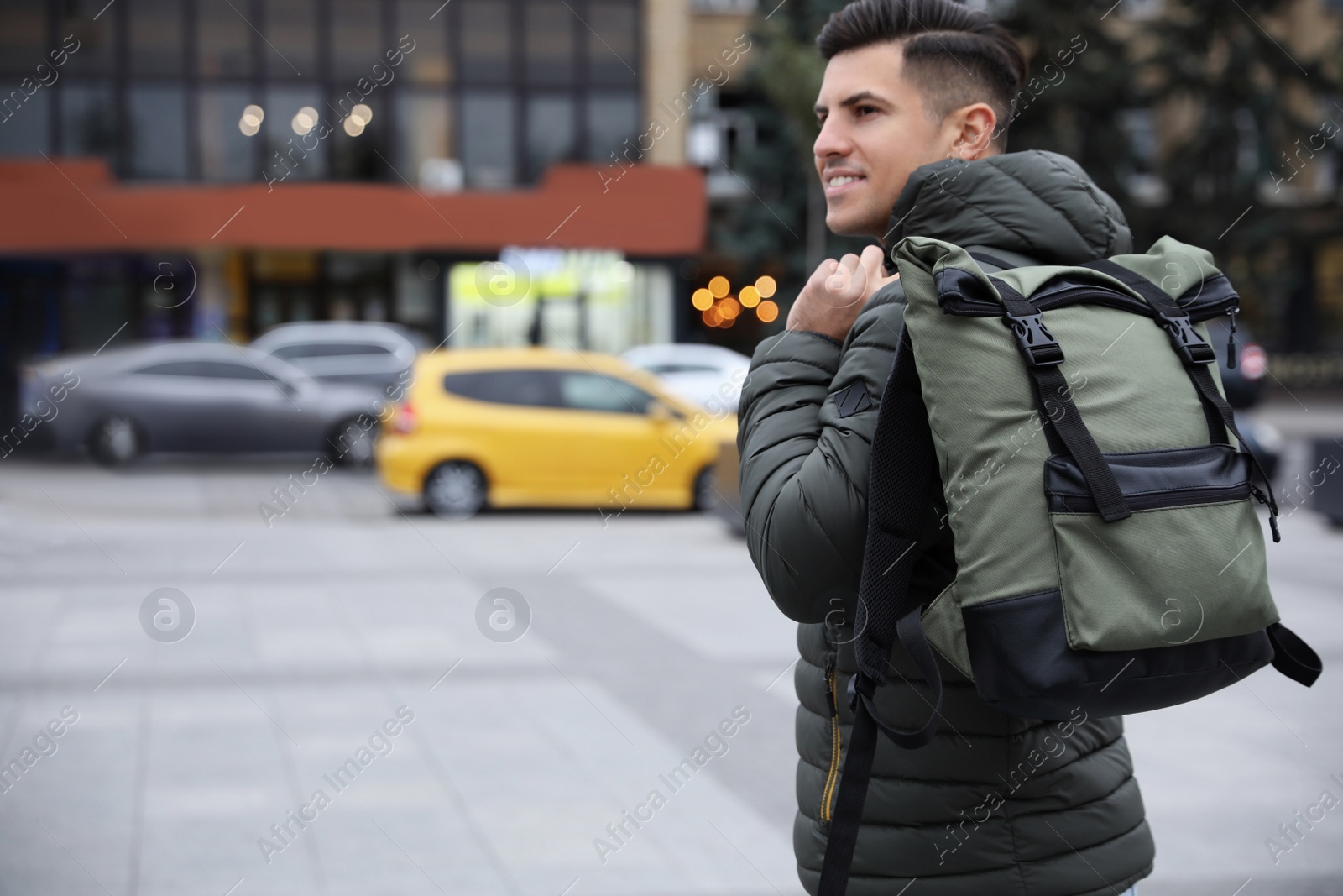 Photo of Male tourist with travel backpack on city street. Urban trip