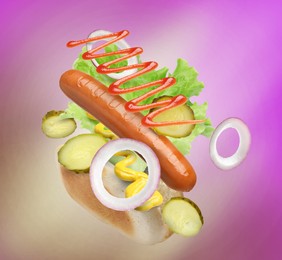 Hot dog ingredients in air on color gradient background
