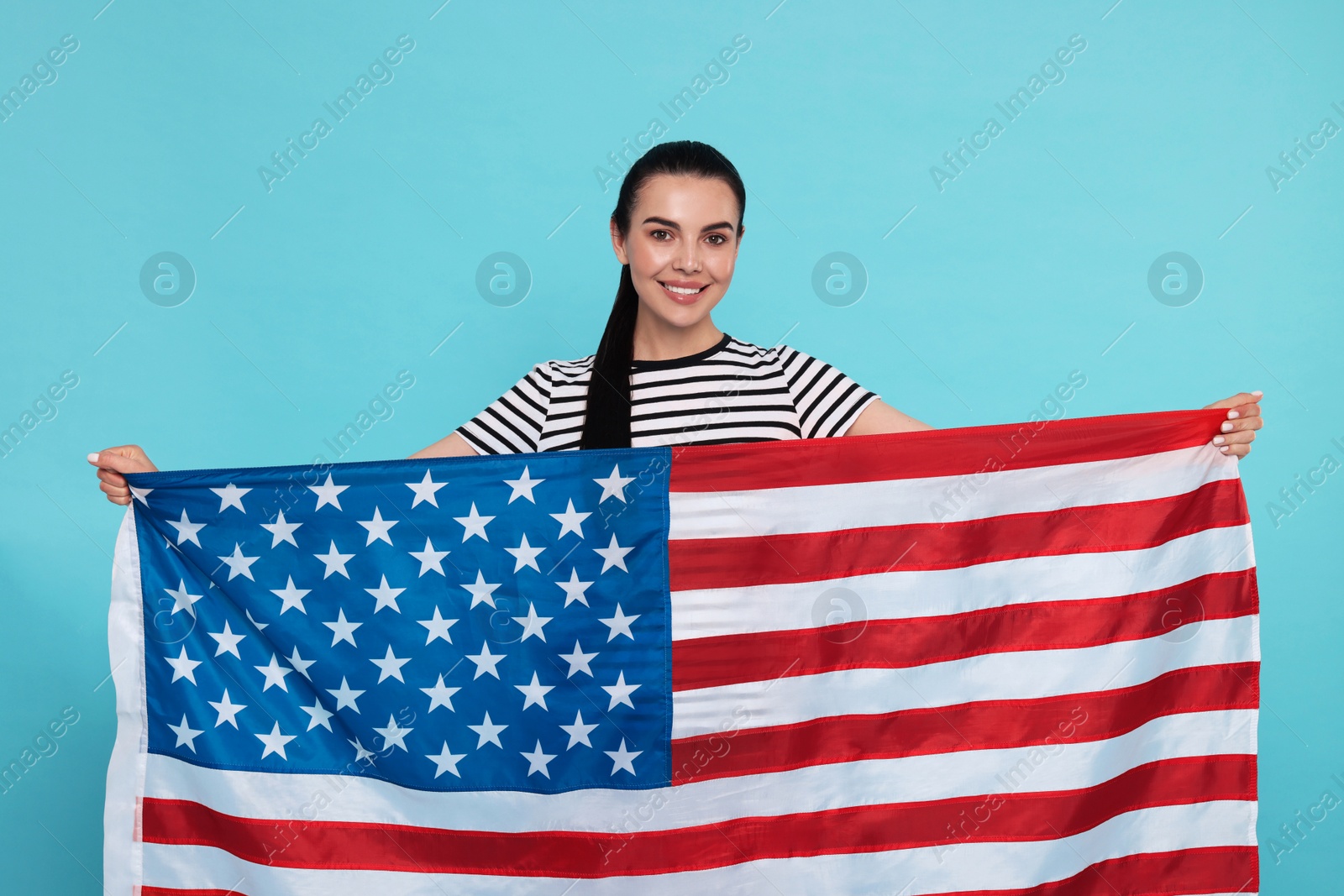 Photo of 4th of July - Independence Day of USA. Happy woman with American flag on light blue background