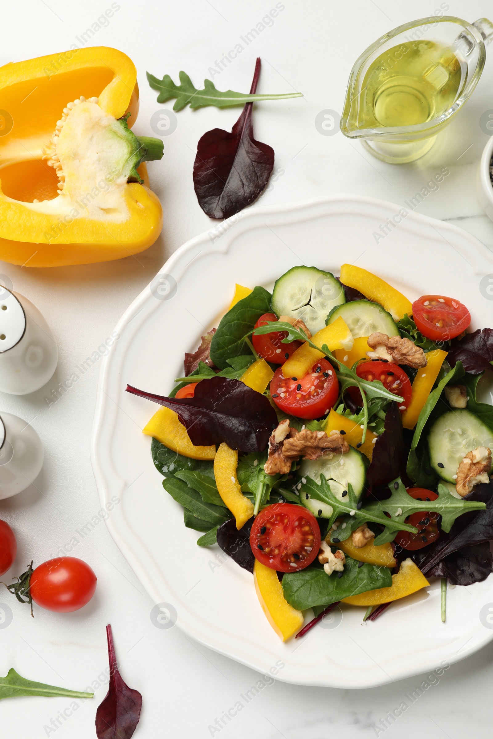 Photo of Tasty fresh vegetarian salad and ingredients on white marble table, flat lay