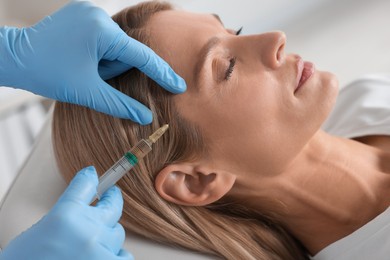 Photo of Trichologist giving injection to patient in clinic, closeup