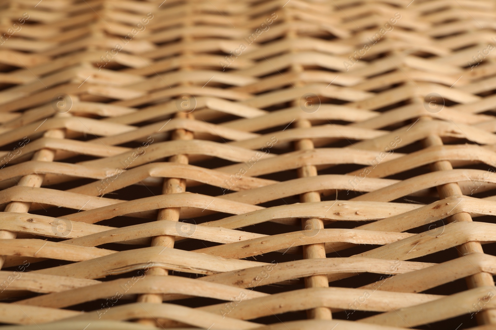 Photo of Handmade wicker basket made of natural material as background, closeup view