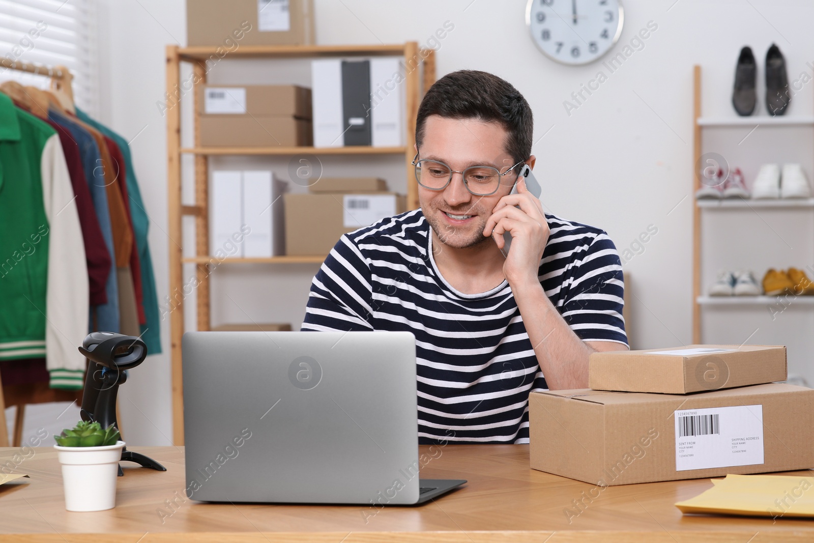 Photo of Seller talking on phone while working in office. Online store