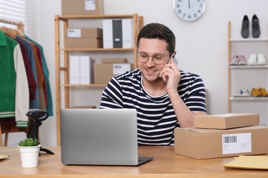 Seller talking on phone while working in office. Online store