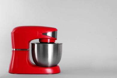 Photo of Modern red stand mixer on light gray background, space for text