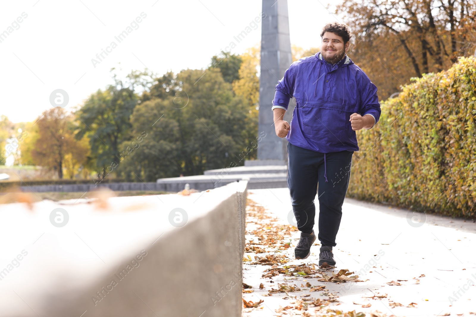 Photo of Young overweight man running in park. Fitness lifestyle