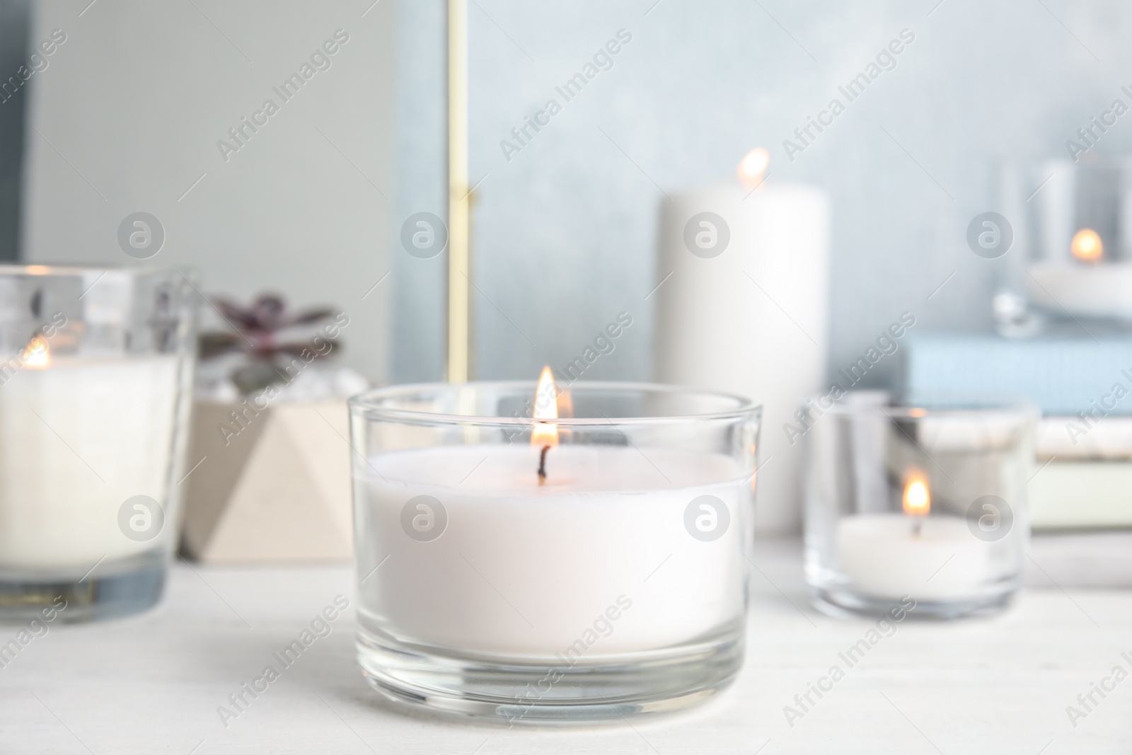 Photo of Burning aromatic candle in holder on table