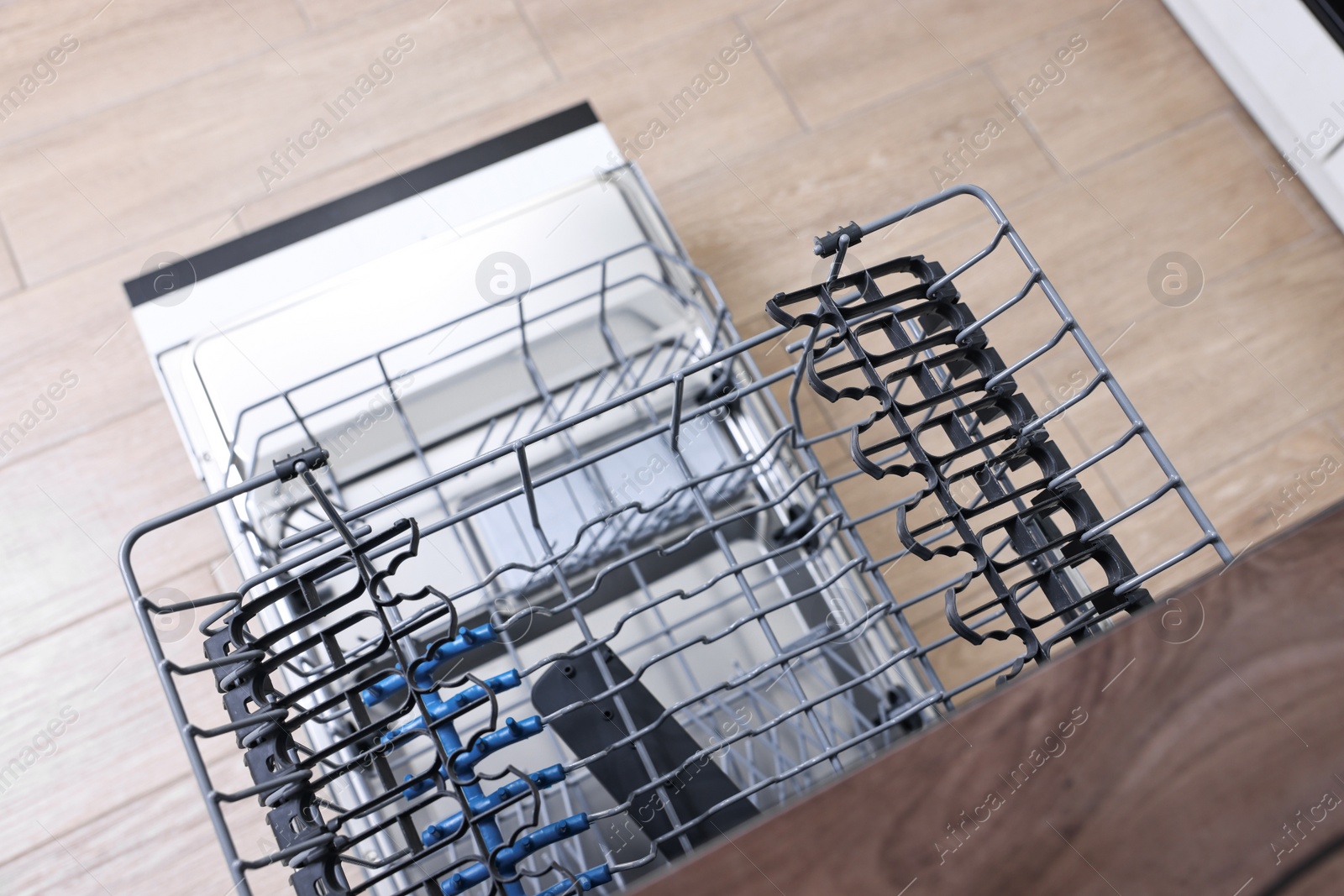 Photo of Open clean empty dishwasher in kitchen, top view