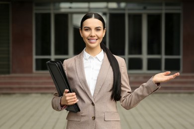 Beautiful real estate agent with documents outdoors