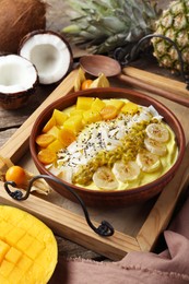 Photo of Tasty smoothie bowl with fresh fruits served on wooden table