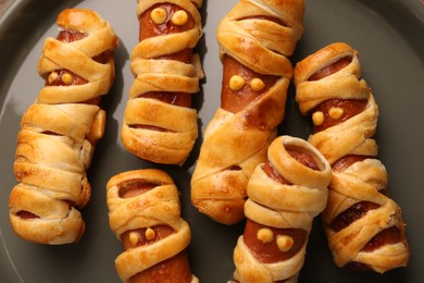 Photo of Cute sausage mummies on plate, closeup. Halloween party food