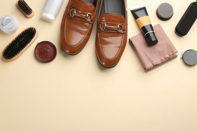 Flat lay composition with shoe care accessories and footwear on beige background. Space for text
