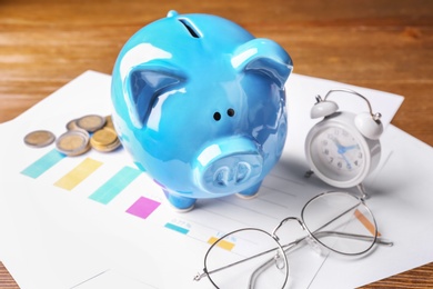 Piggy bank, coins and alarm clock on table. Pension planning