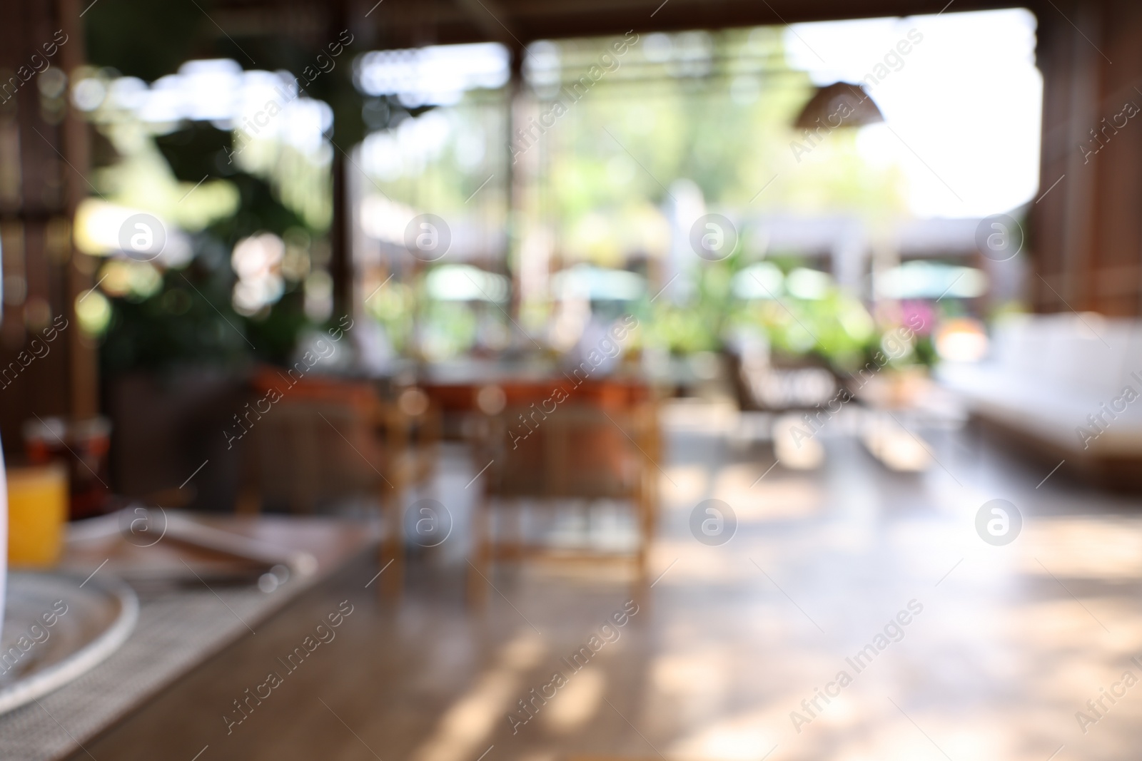 Photo of Blurred view of comfortable cafeteria with furniture