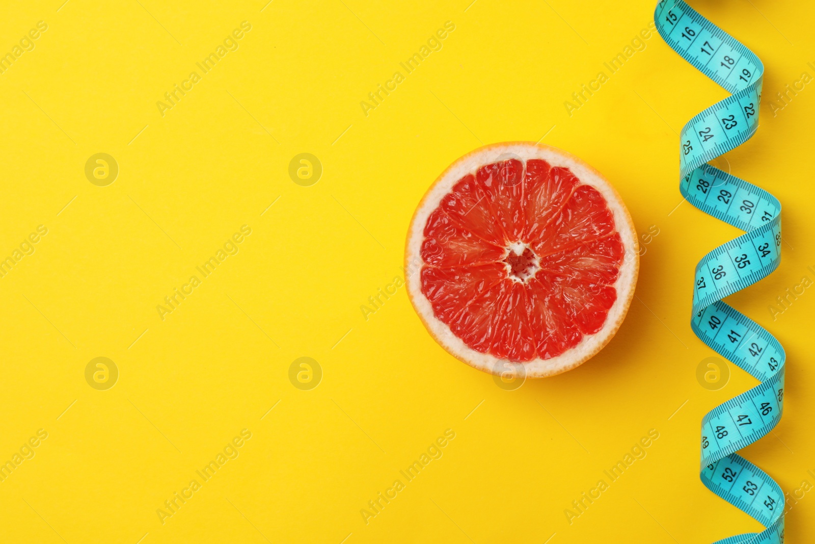 Photo of Tasty fresh grapefruit and measuring tape on color background, top view. Healthy diet