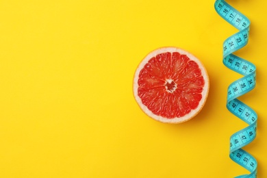 Photo of Tasty fresh grapefruit and measuring tape on color background, top view. Healthy diet