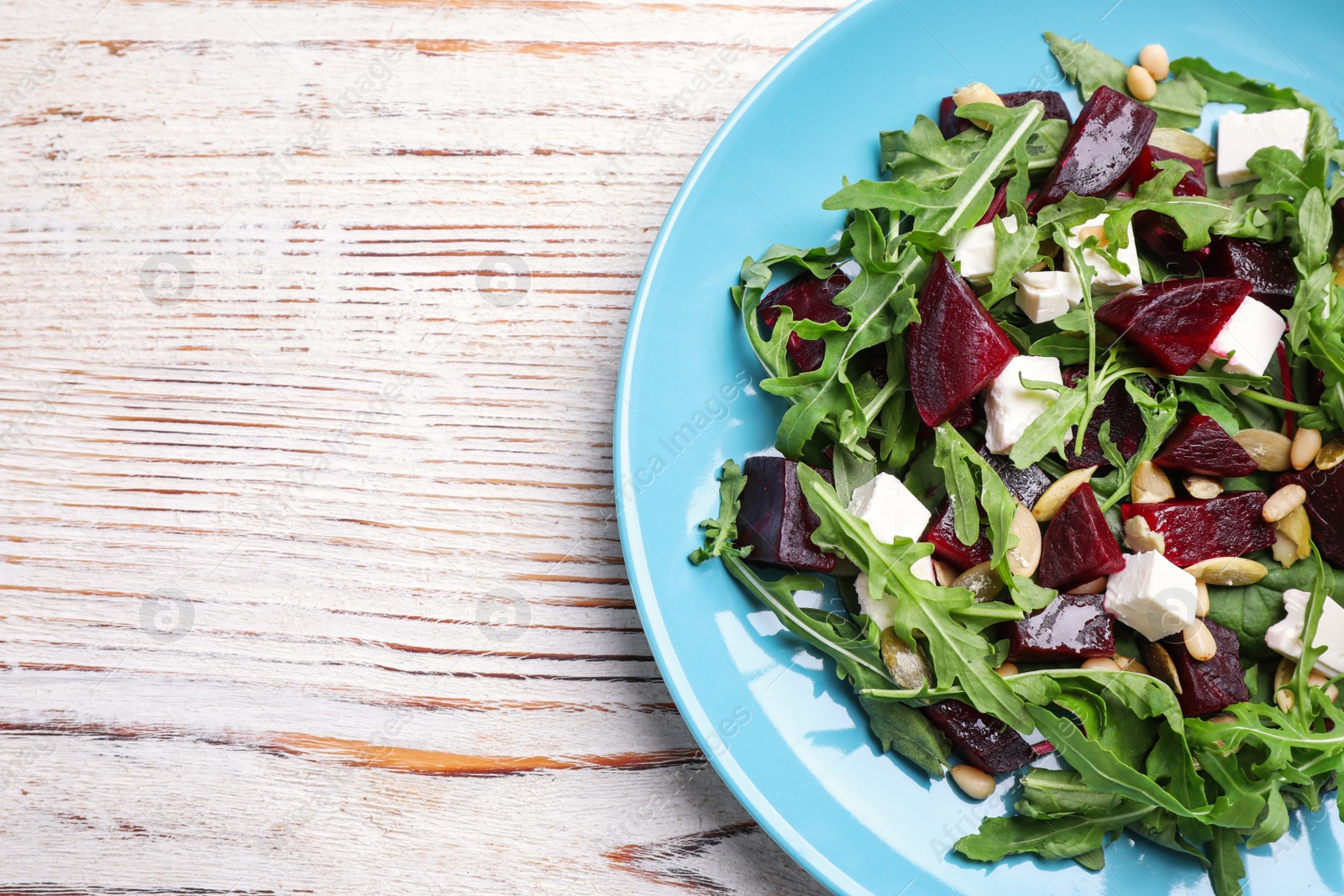 Photo of Fresh delicious beet salad on white wooden table, top view. Space for text