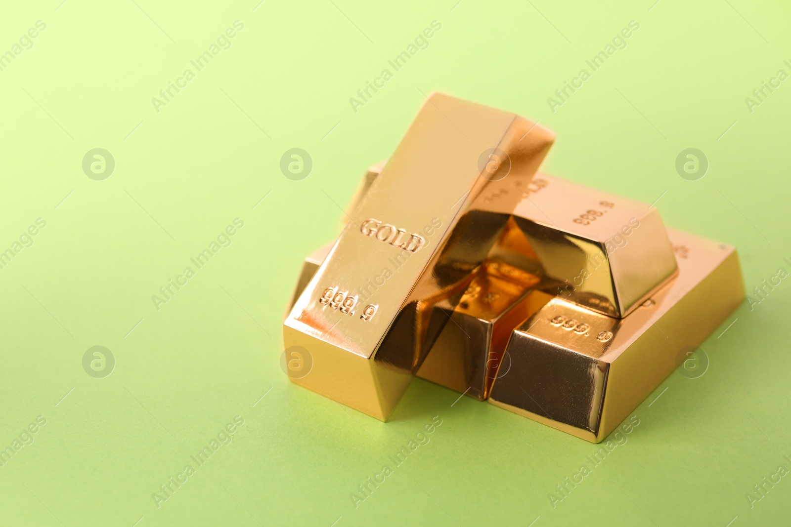 Photo of Precious shiny gold bars on color background. Space for text