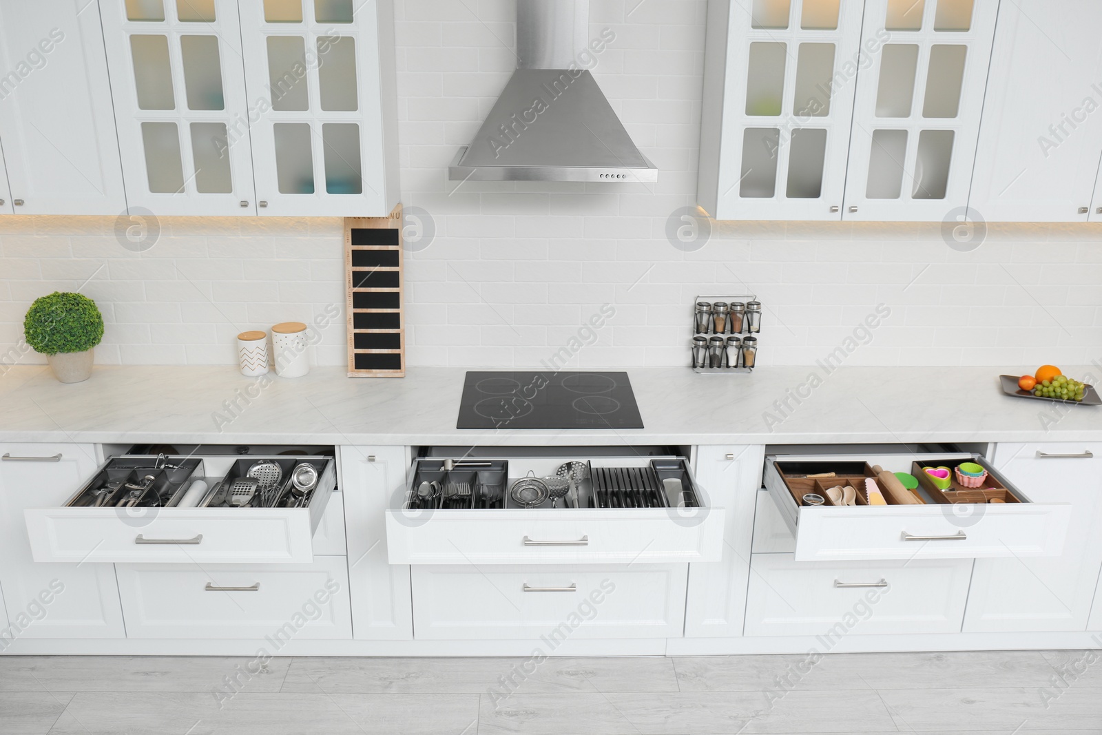 Photo of Open drawers with different utensils in kitchen