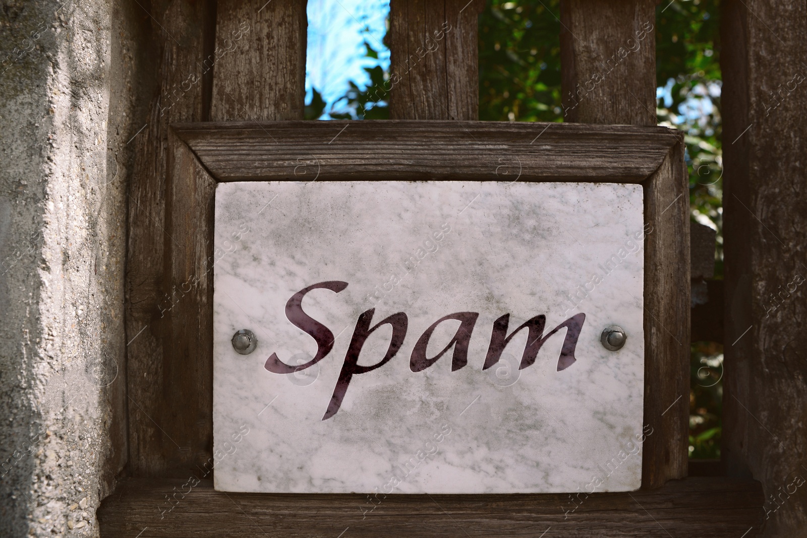 Image of Metal sign with word Spam on wooden fence outdoors