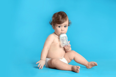 Photo of Cute little baby in diaper on light blue background