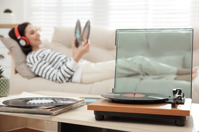 Photo of Woman listening to music with turntable in living room