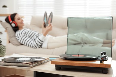 Woman listening to music with turntable in living room