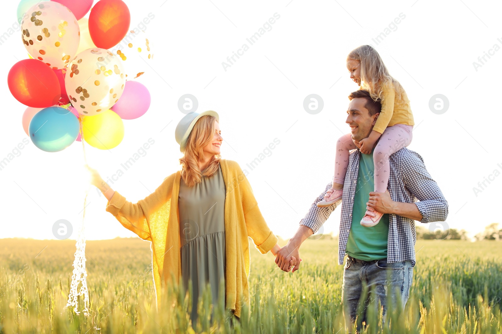 Photo of Happy family with colorful balloons outdoors on sunny day