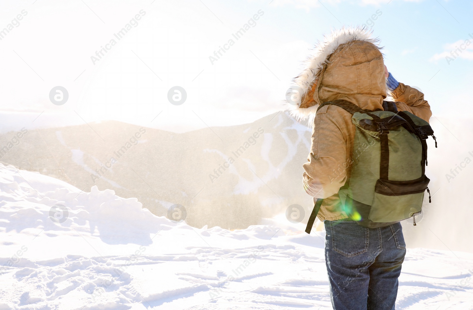 Photo of Woman with backpack enjoying mountain view during winter vacation. Space for text