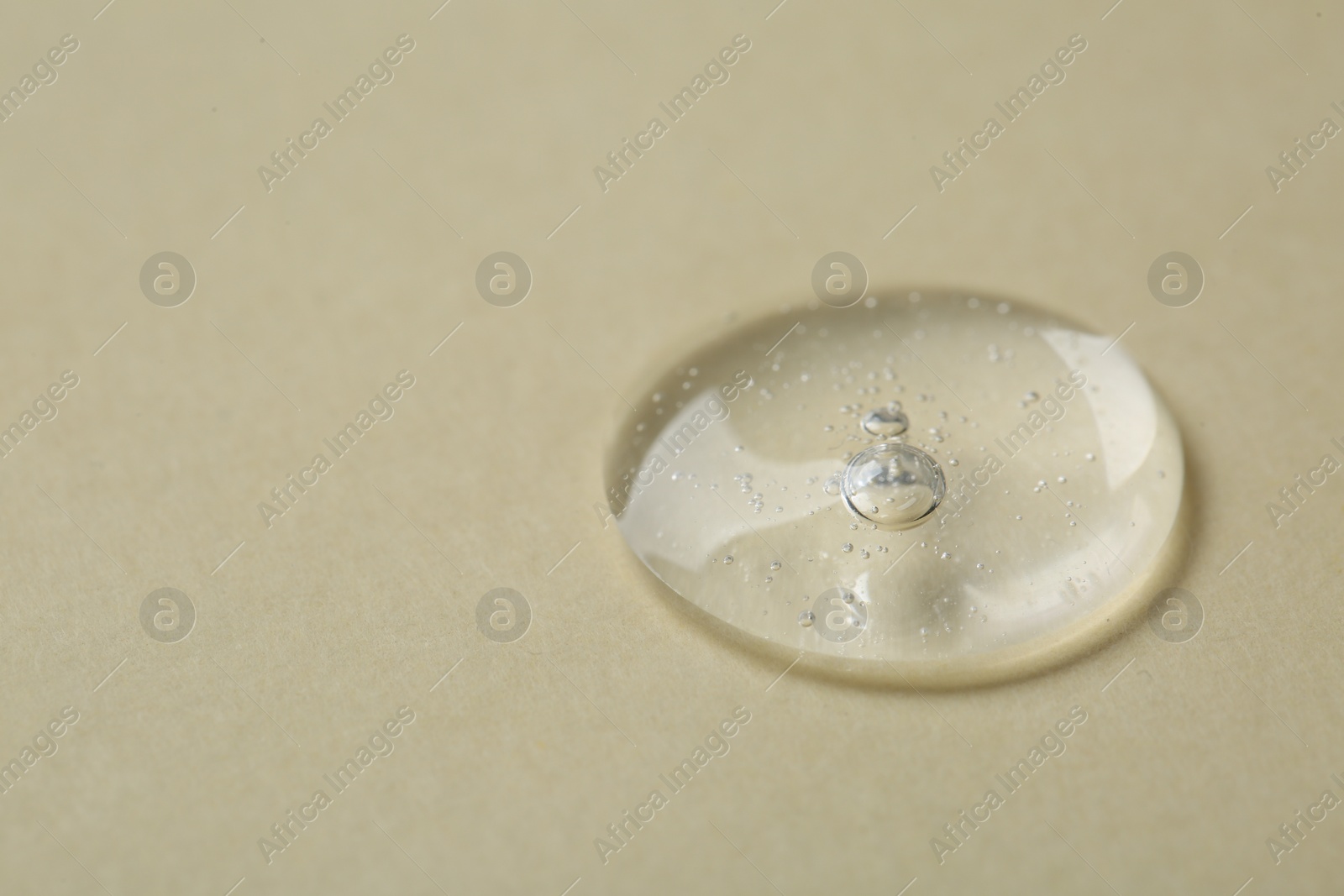 Photo of Sample of cosmetic serum on beige background, closeup. Space for text