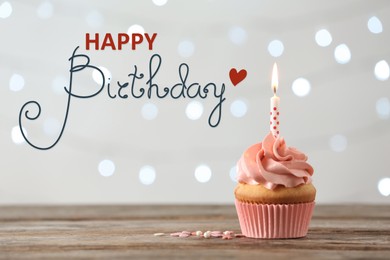 Image of Happy Birthday! Delicious cupcake with burning candle on wooden table 