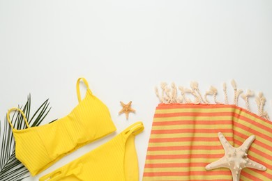 Photo of Beach towel and swimsuit on light background, flat lay. Space for text