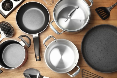 Photo of Flat lay composition with clean cookware on wooden background