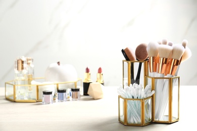 Set of makeup products and brushes on table. Space for text