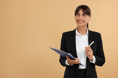 Photo of Happy secretary with clipboard and pen on beige background. Space for text