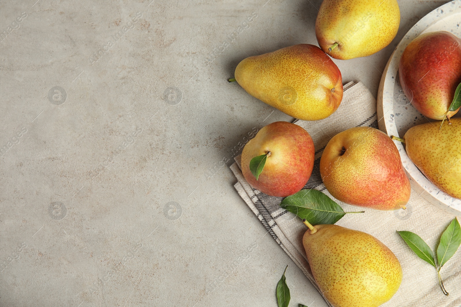 Photo of Ripe juicy pears on grey stone table, flat lay. Space for text