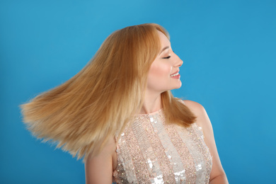 Photo of Beautiful young woman with blonde hair on blue background