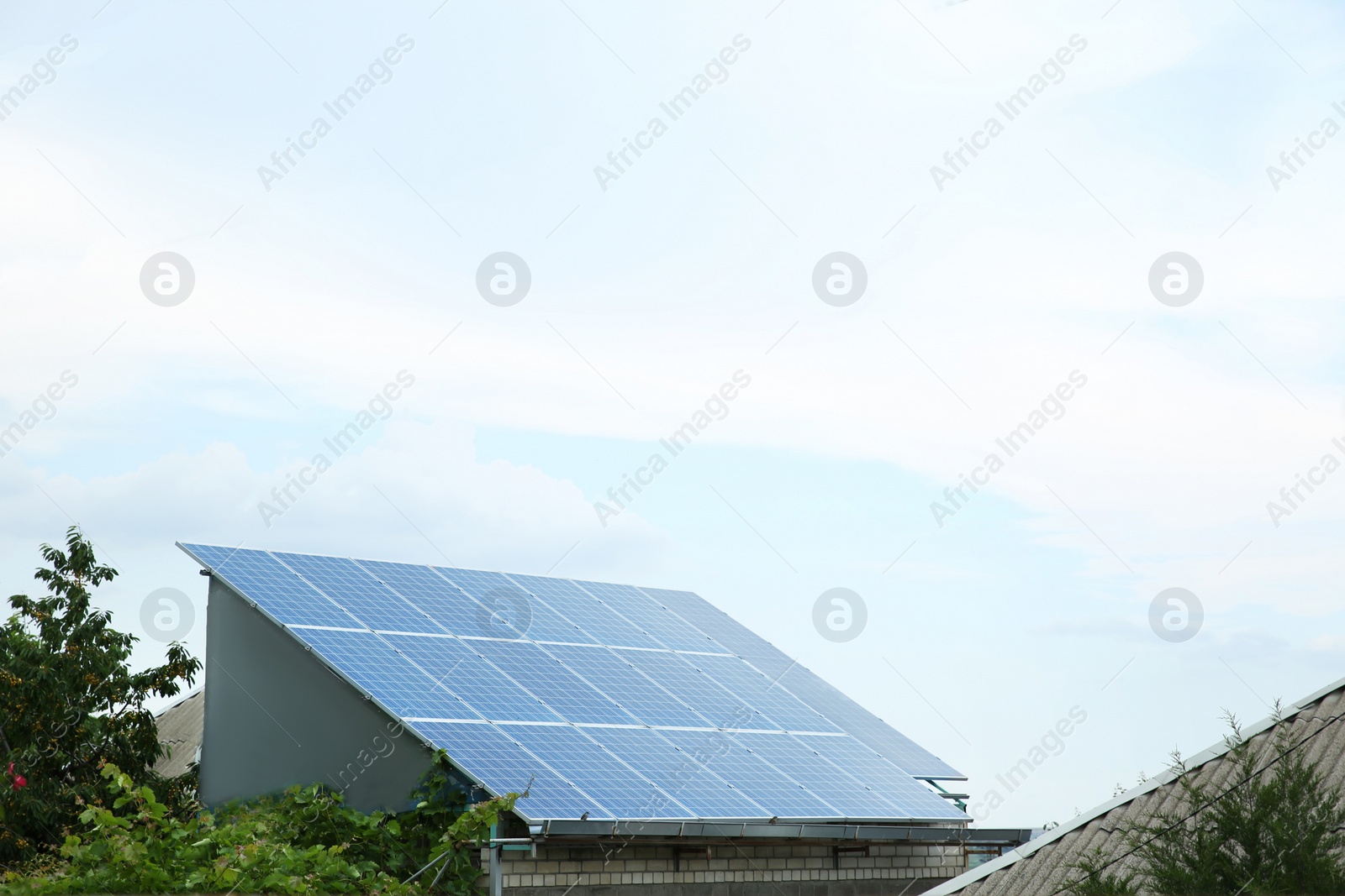 Photo of House with installed solar panels on roof. Alternative energy source