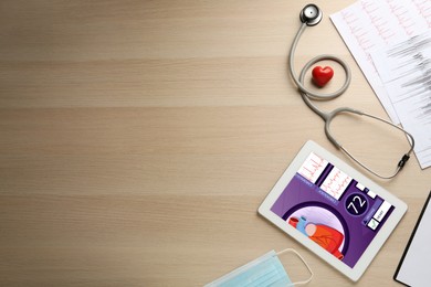 Photo of Flat lay composition with tablet and red heart on wooden table, space for text. Cardiology concept