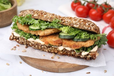 Photo of Delicious sandwich with schnitzel on white table