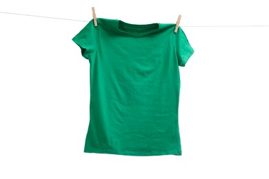 Photo of One green t-shirt drying on washing line isolated on white