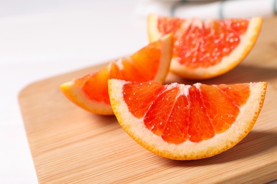 Photo of Slices of red orange on wooden board, closeup
