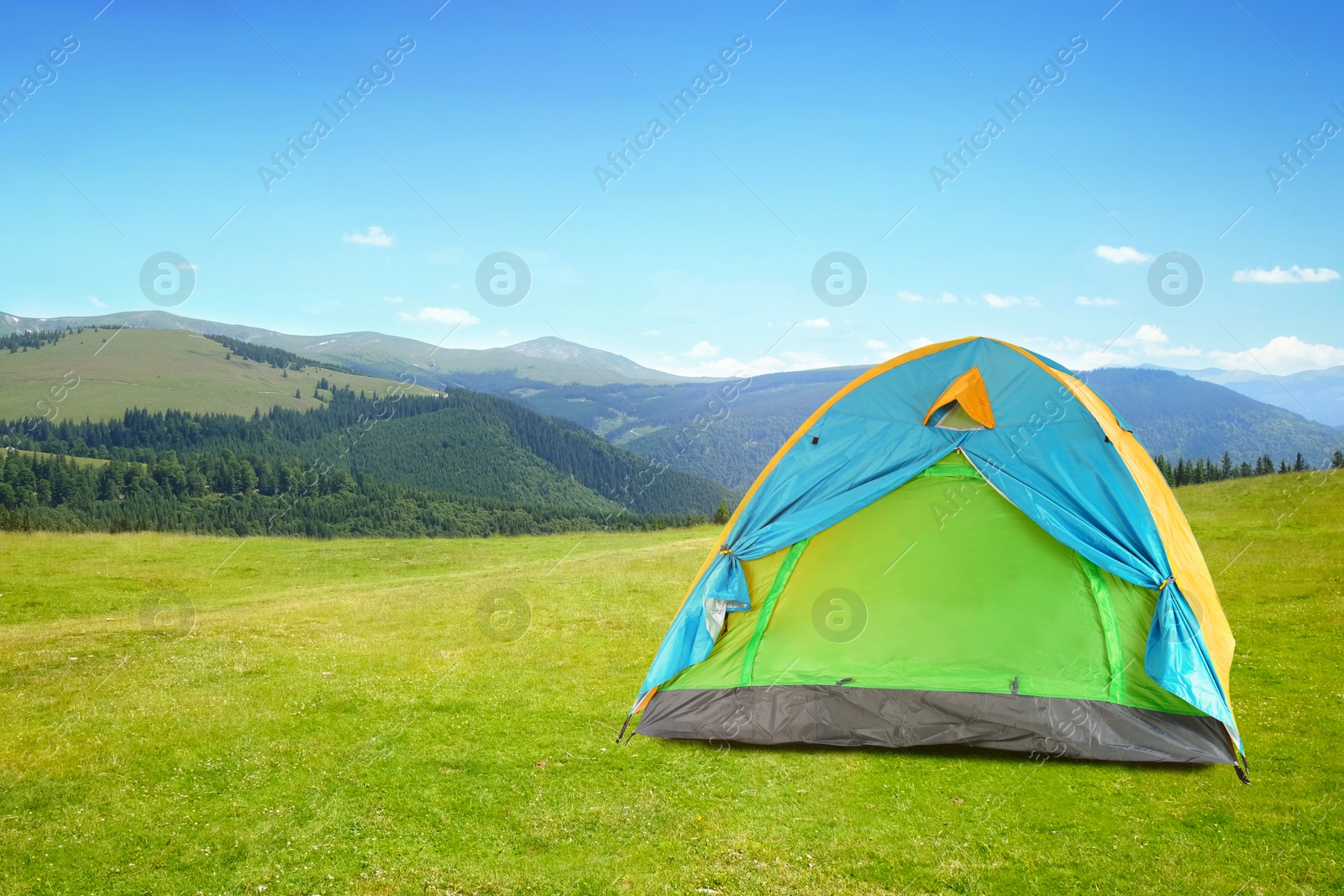 Image of Modern camping tent in mountains on sunny day