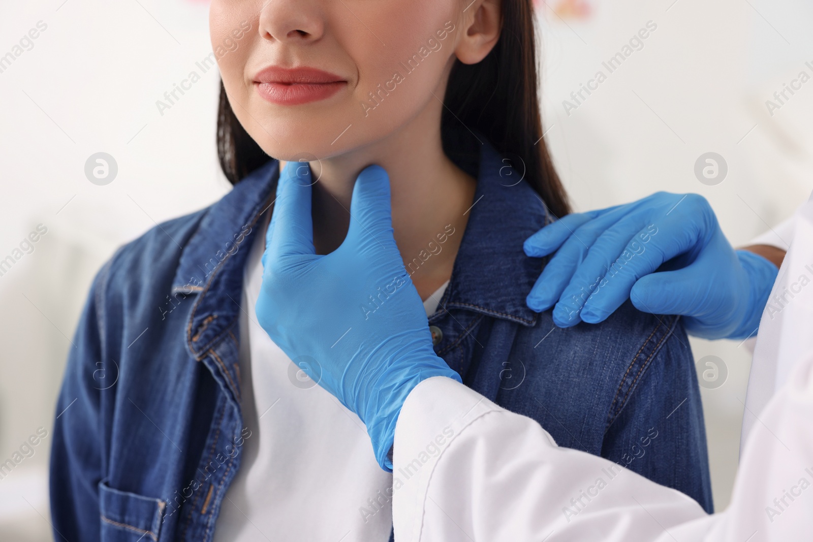 Photo of Endocrinologist examining thyroid gland of patient at hospital, closeup