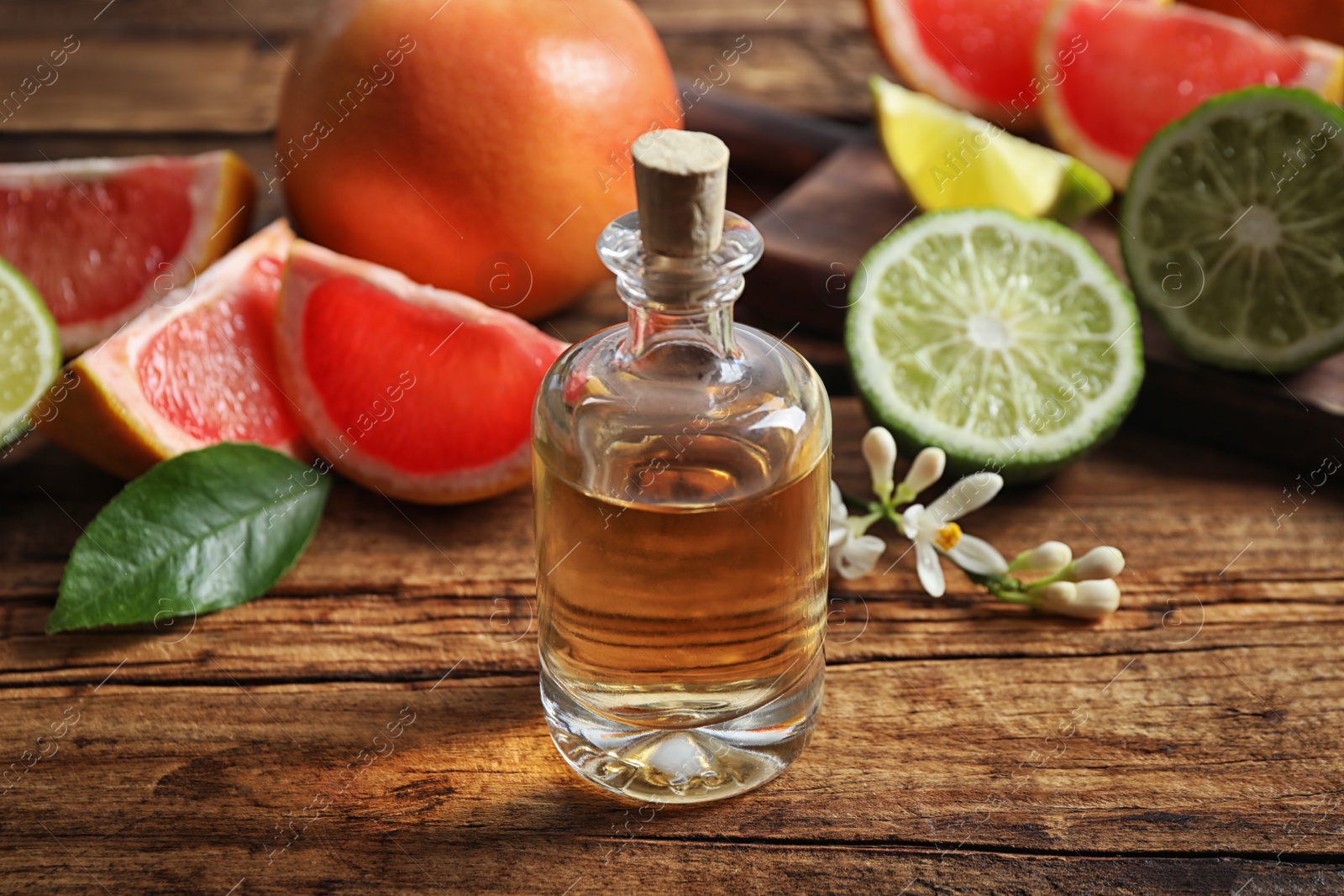 Photo of Bottle of citrus essential oil on wooden table