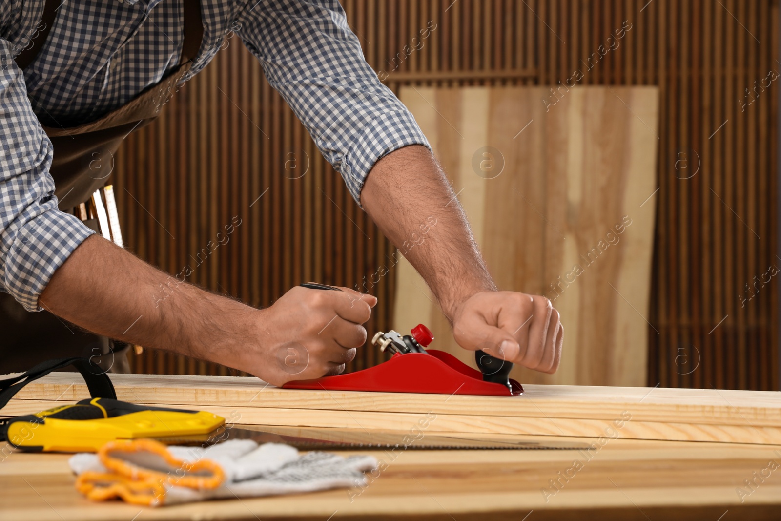 Photo of Carpenter working with timber at table indoors, closeup