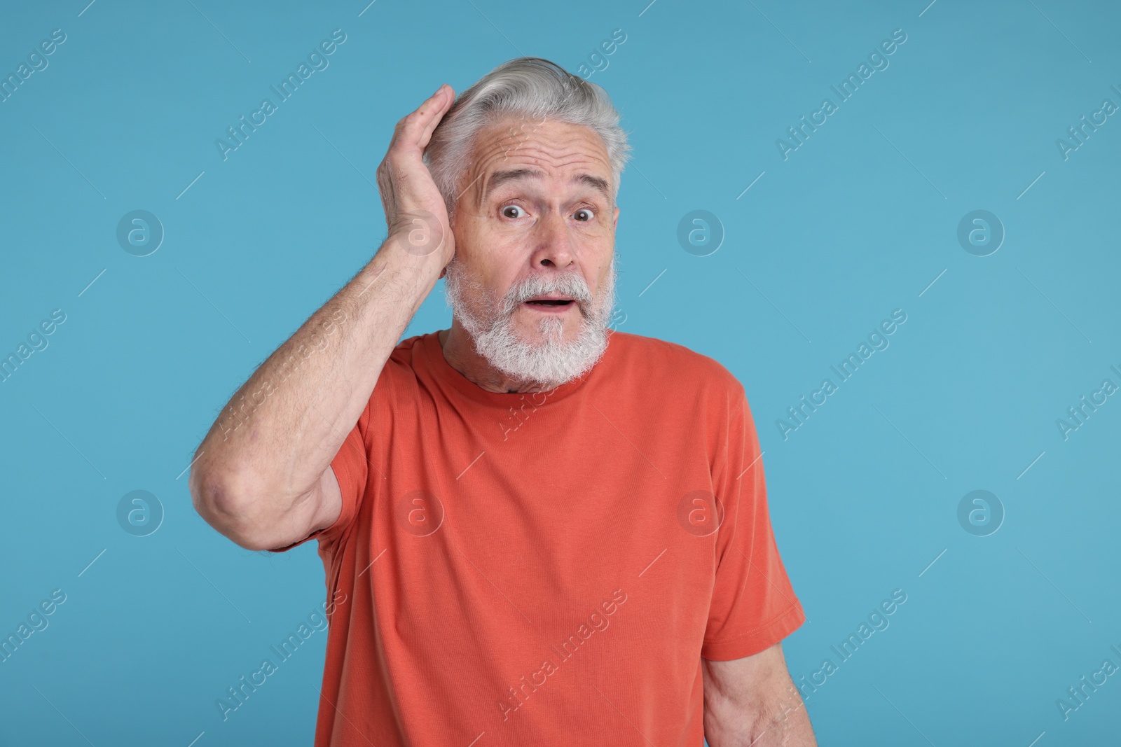 Photo of Portrait of surprised senior man on light blue background