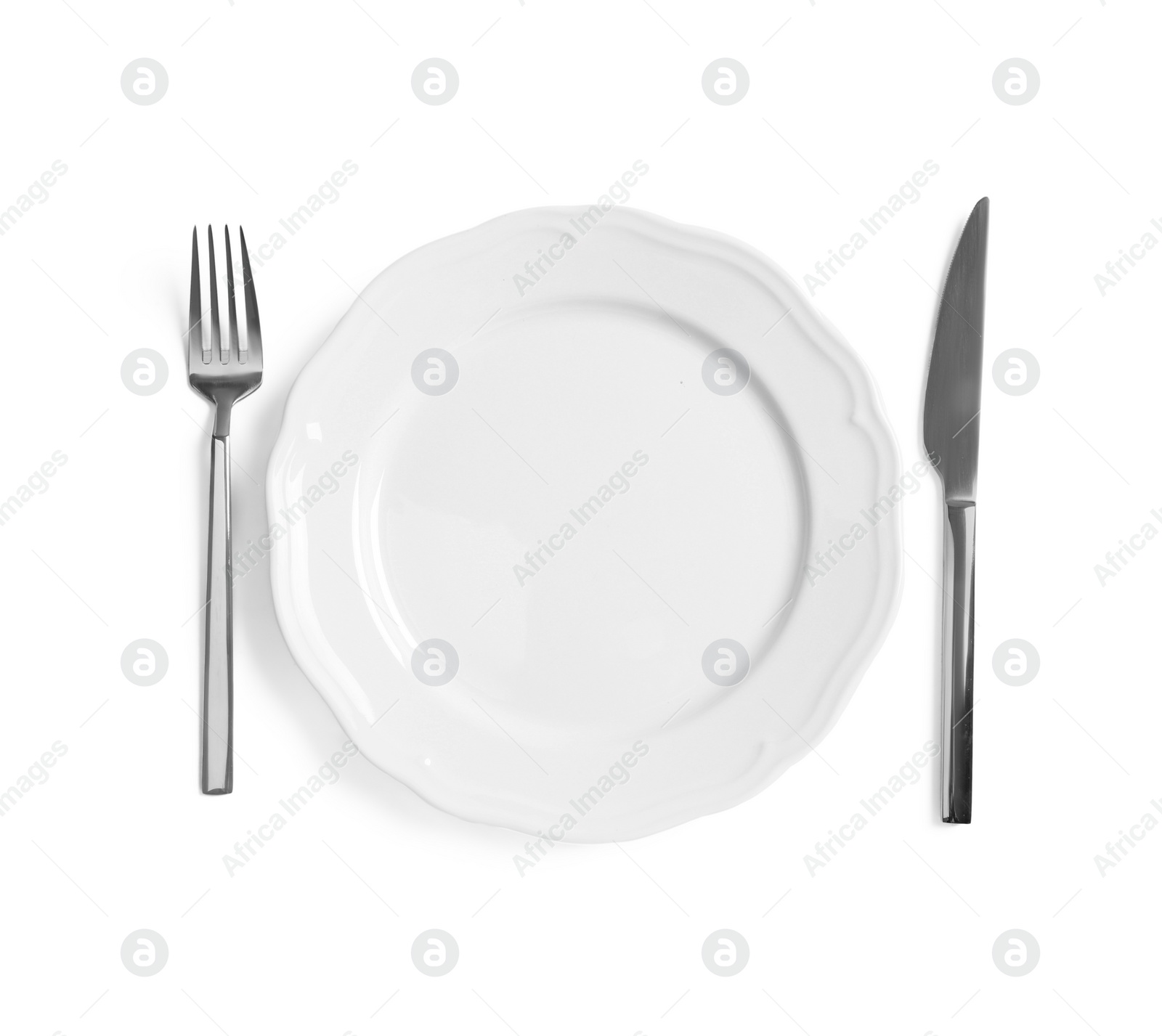 Photo of Clean plate and shiny cutlery on white background, top view